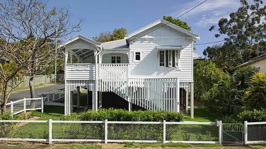 white Queenslander homes with a white picket fence