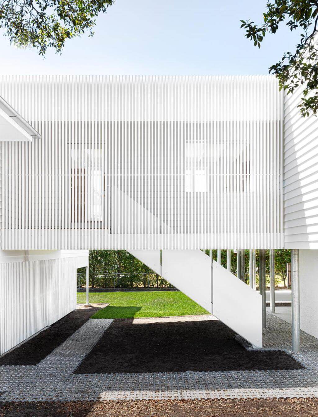 Modern Queenslander Residence white building with a staircase leading up to it

