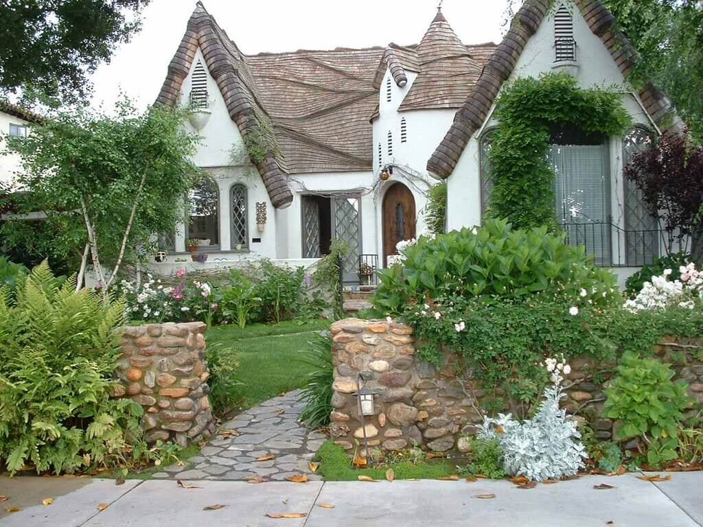 White Storybook style homes with a stone pathway leading to it 