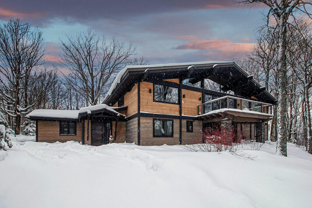 chalet style homes with snow in the ground and roof