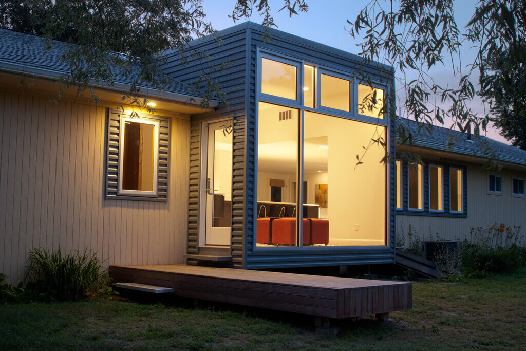 rambler homes ranch style house with a deck in front of it 