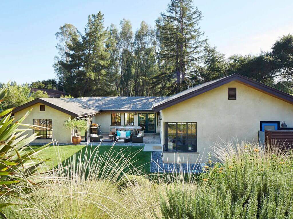 A house in the middle of a lush green field
