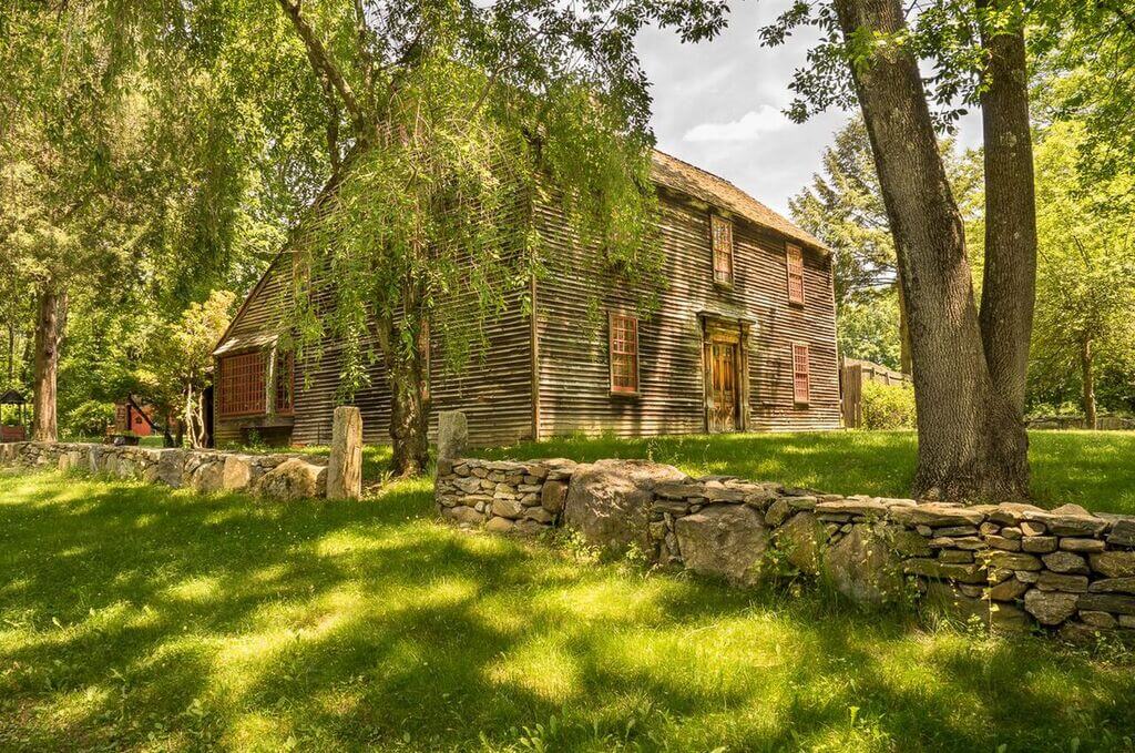 saltbox style house in the middle of a field 