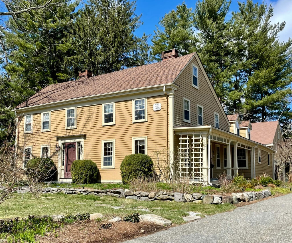  yellow saltbox style house red door and windows