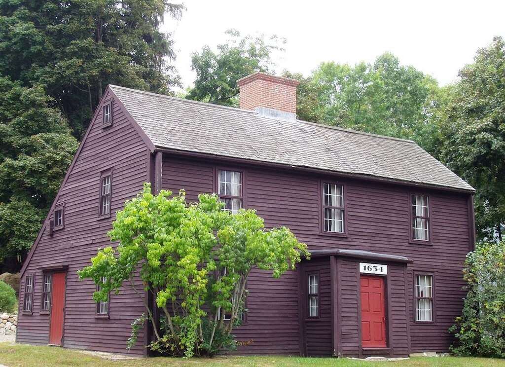 purple saltbox style house  with a red door
