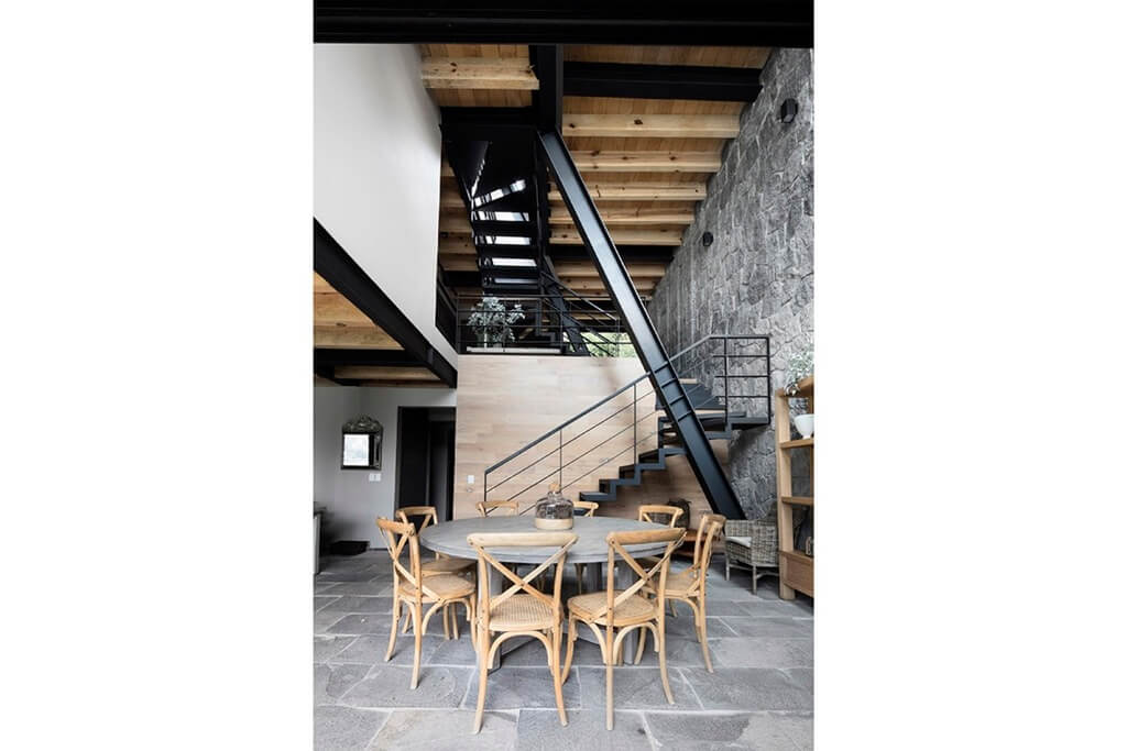 A table and chairs in front of a staircase
in Casa A Método