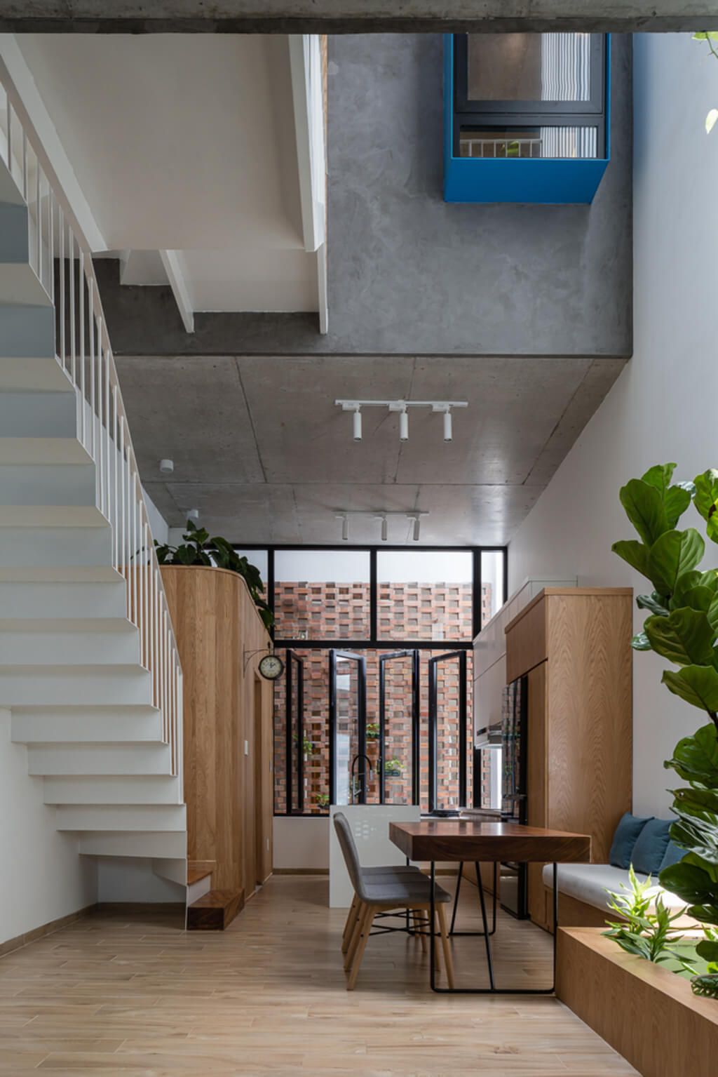 A living area with a table, stairs, and plants
