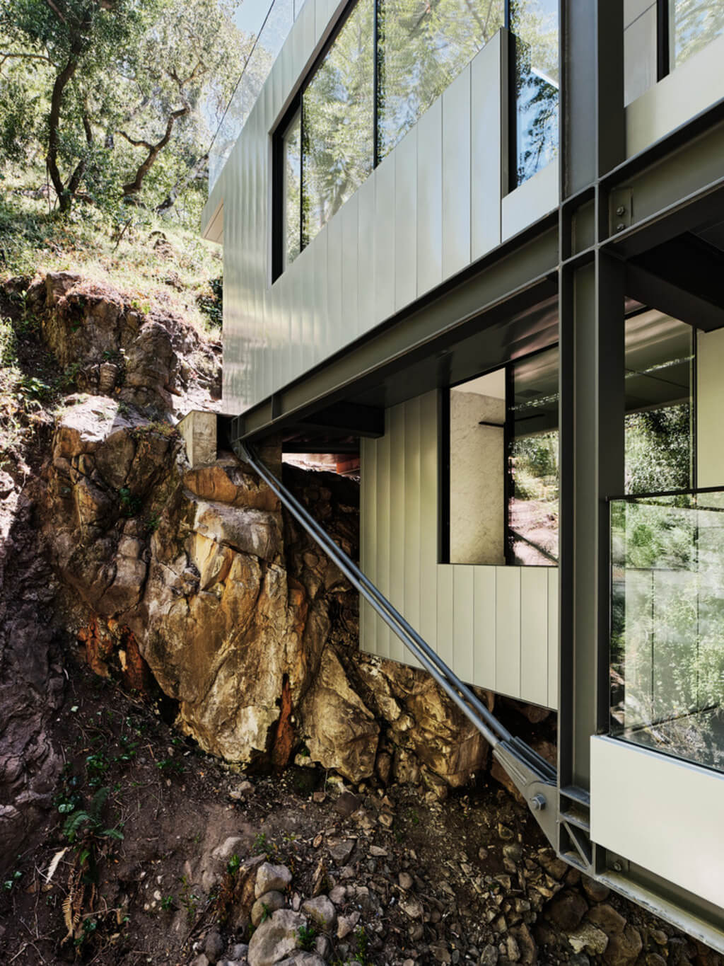 Suspension House on a hill with a large rock in front of house