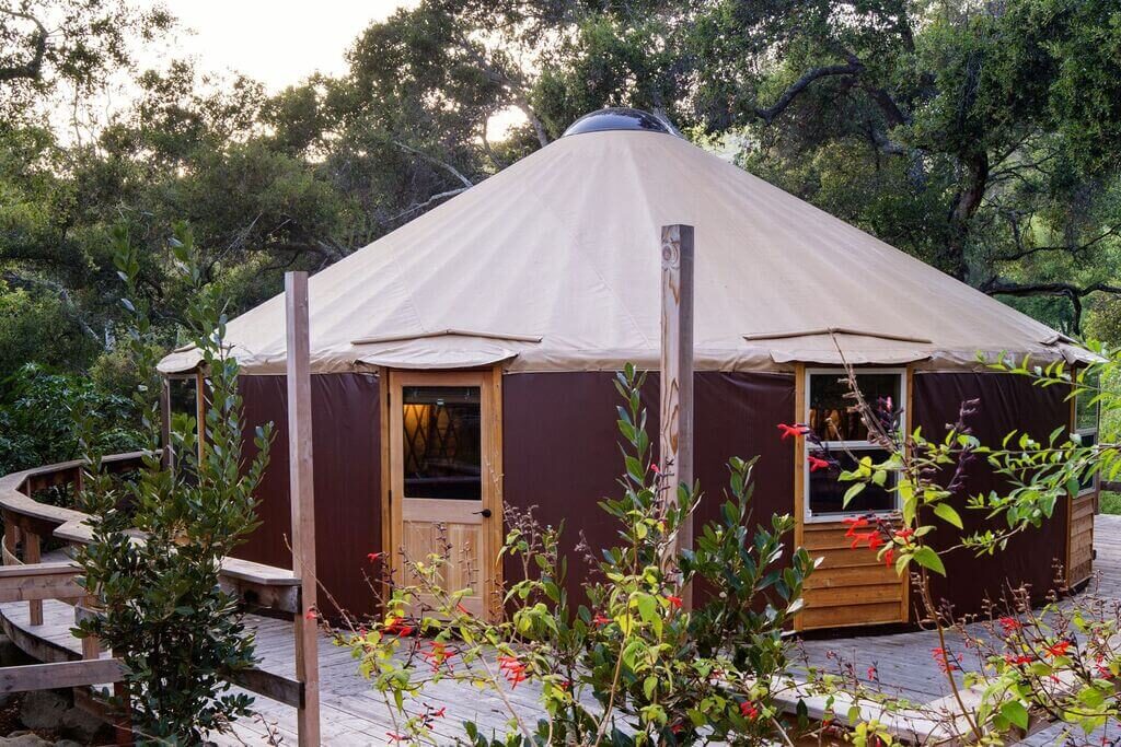 A yurt in the middle of a wooded area
