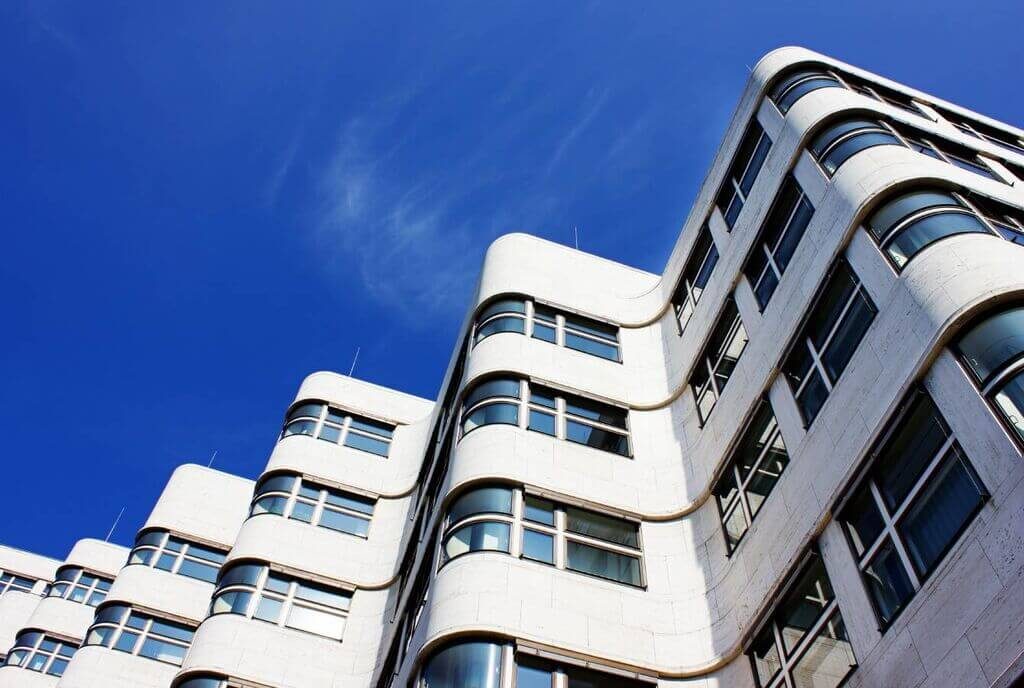 A tall white building with lots of windows
