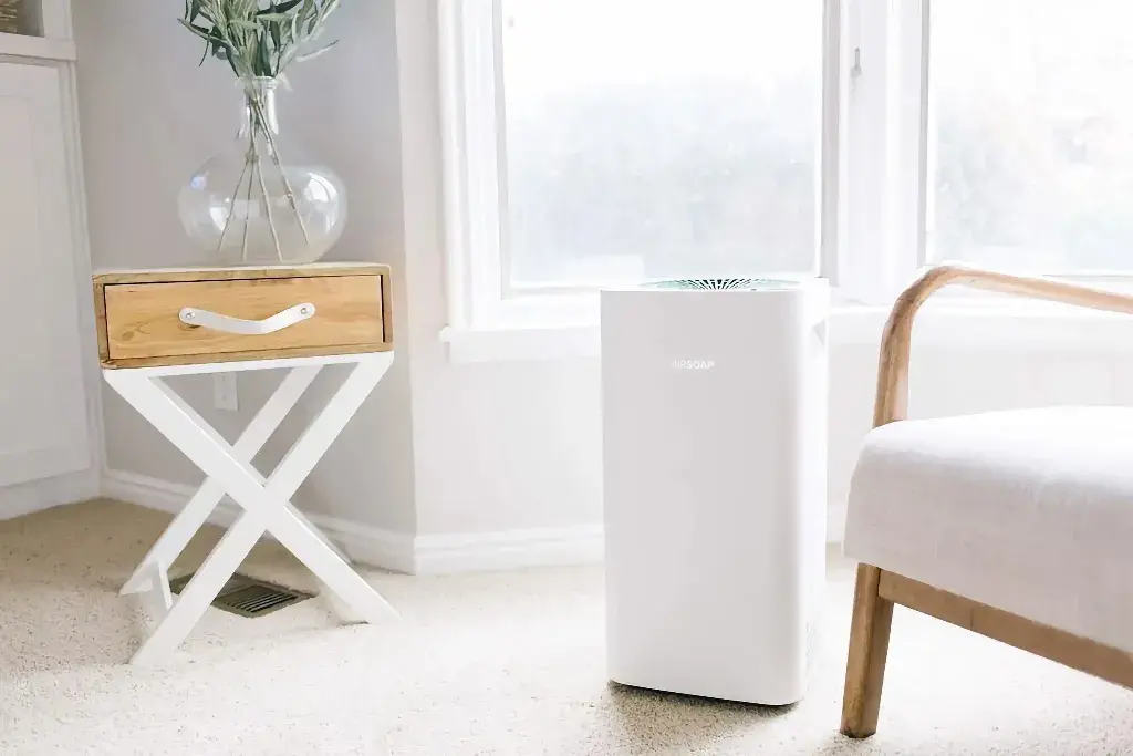 A white air purifier next to a window
