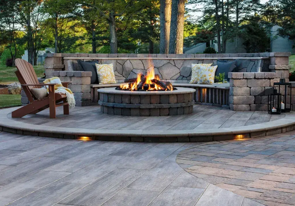 A patio with a gas fire pit surrounded by chairs