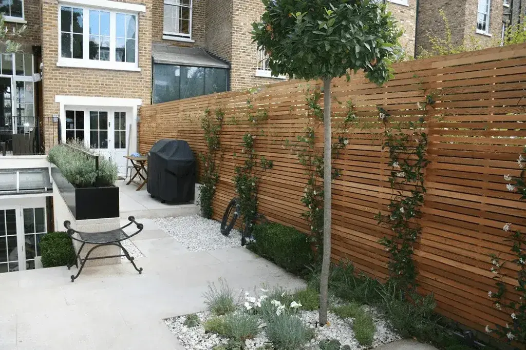 A backyard with a wooden fence and a chair
