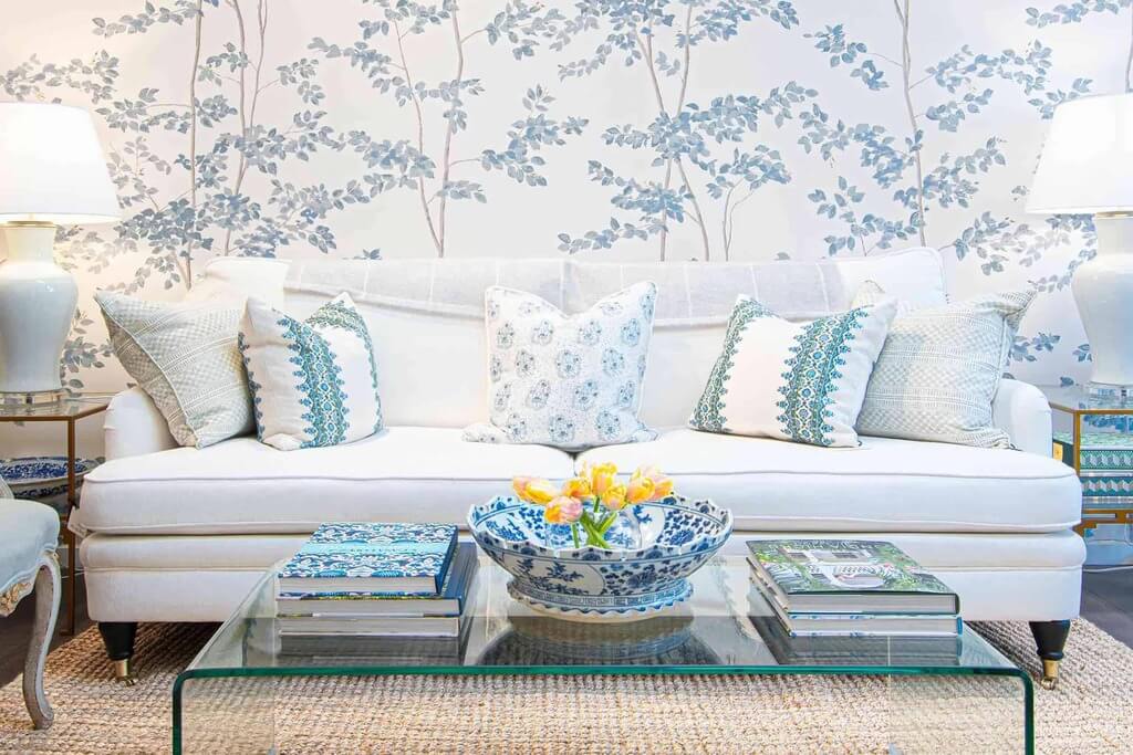 A living room with a white couch and  wallpaper
