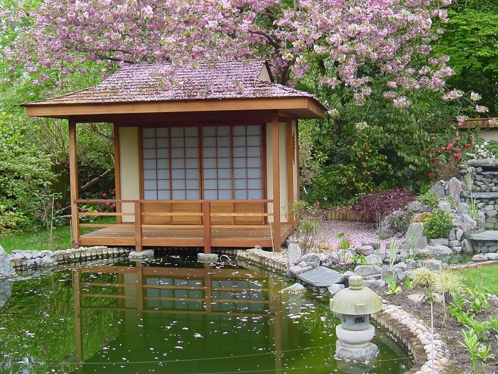 A japanese garden with a pond and a gazebo
