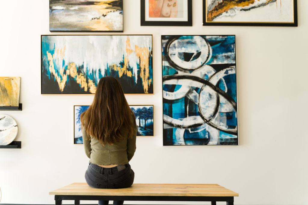 girl sitting front of wall art