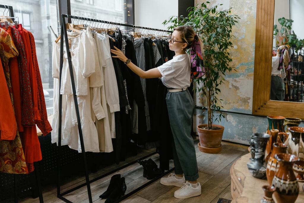  woman looking at clothes hanging in the rack
